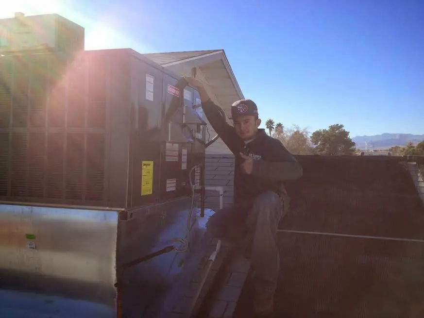 HVAC technician performing AC Tune-Up on a rooftop unit in La Feria